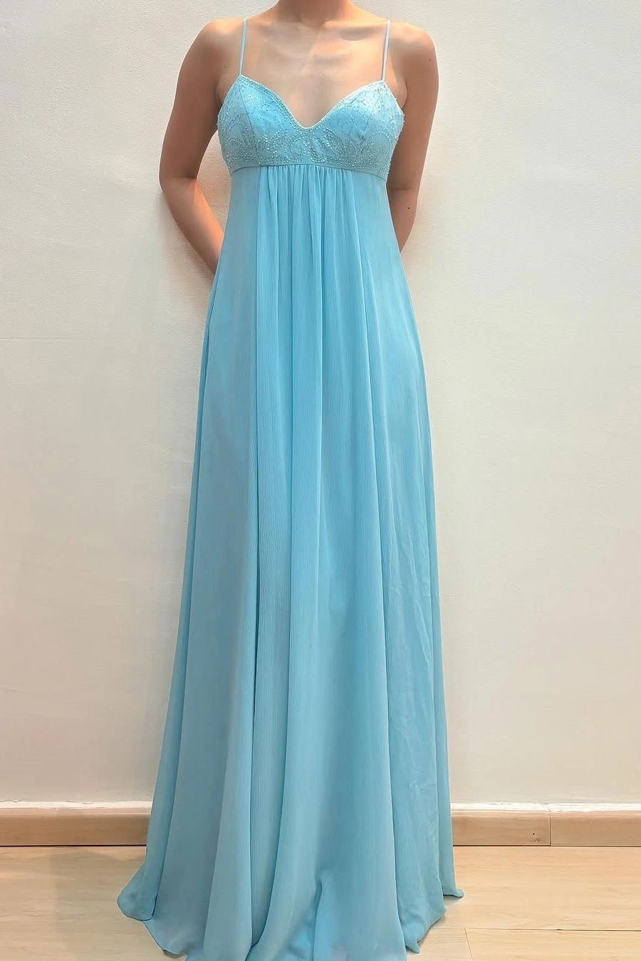 Front view of a Loverlm aqua blue chiffon A-line prom dress with an embellished V-neck bodice, spaghetti straps, empire waist, and flowing floor-length skirt.