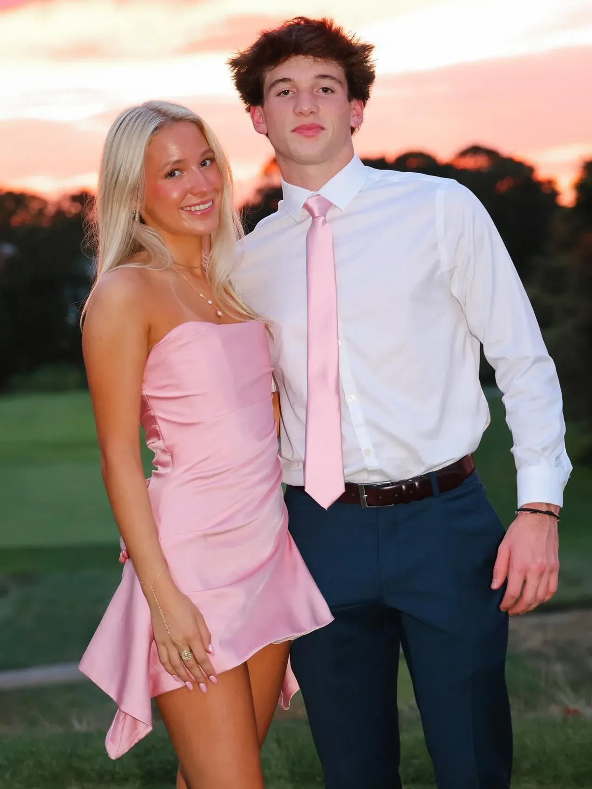 Loverlm baby pink strapless mini homecoming dress with a fitted ruched bodice and asymmetric draped hem, styled for a homecoming couple photo
