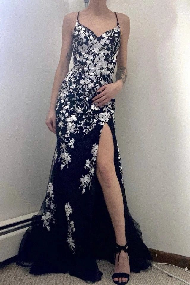 Front view of a Loverlm black lace tulle mermaid prom dress with a V-neckline, spaghetti straps, white floral appliqués, and high slit.