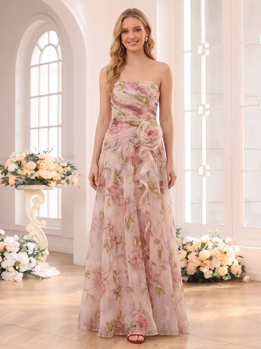 Front view of Loverlm blush pink floral strapless wedding guest dress with ruched bodice, 3D rose waist detail and A-line skirt