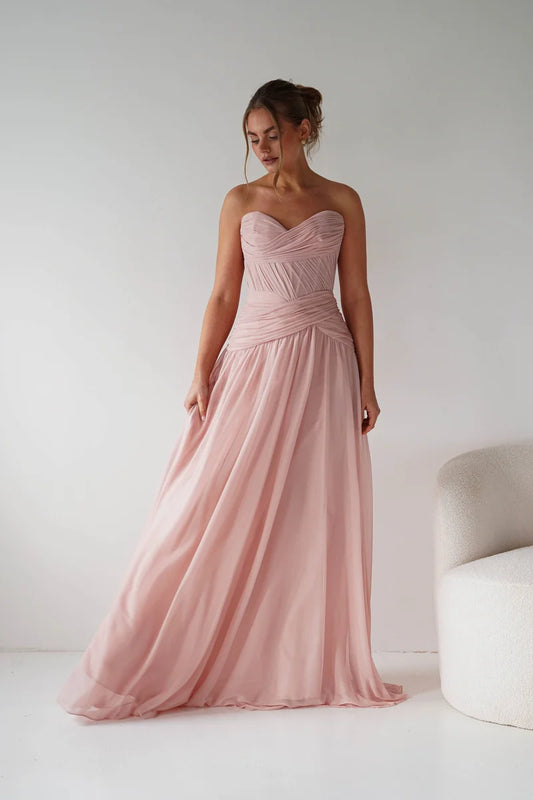 Loverlm blush pink A-line bridesmaid dress featuring a strapless sweetheart neckline, pleated bodice, crossover waist and flowing floor-length skirt front view