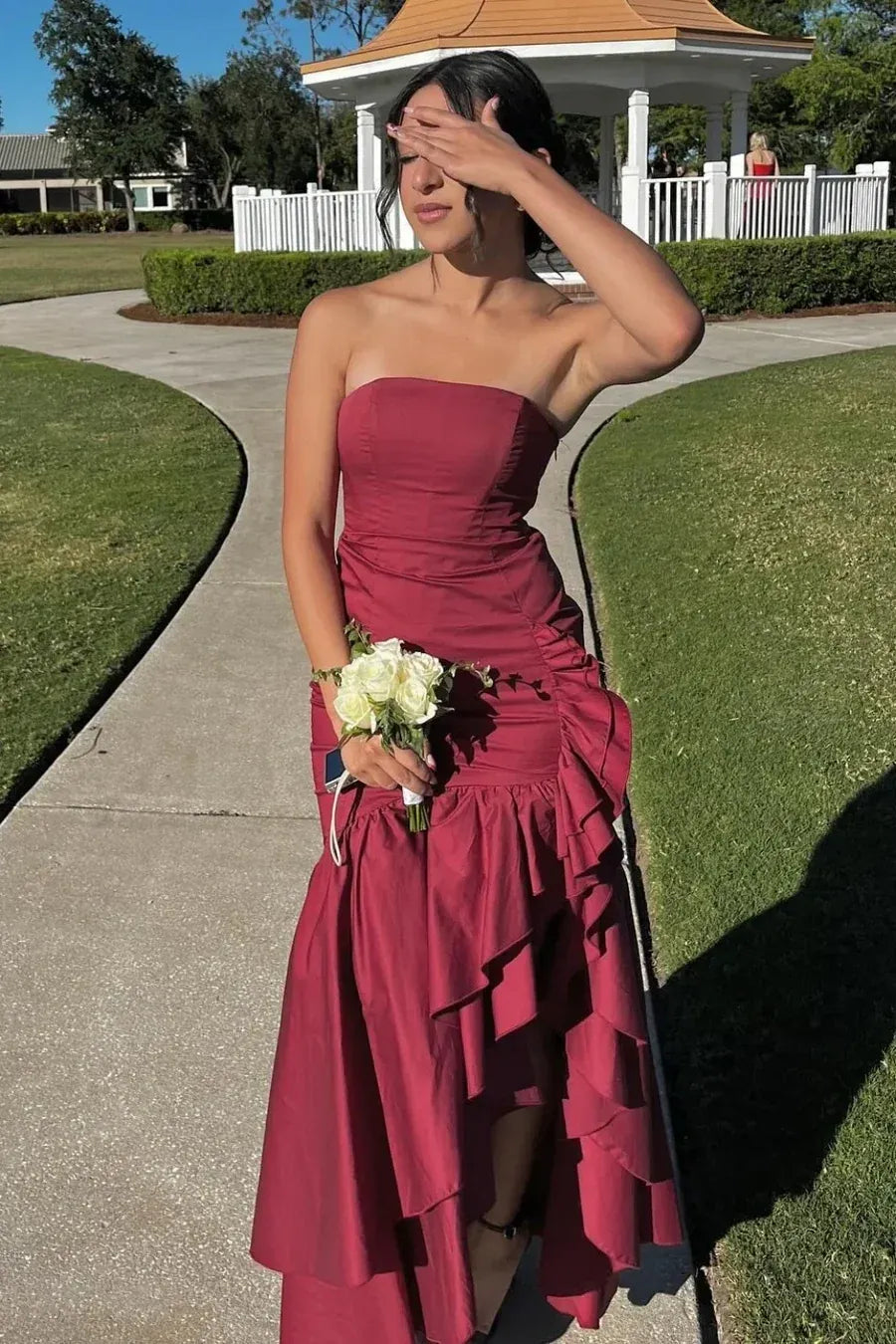 Loverlm burgundy strapless sheath prom dress with ruched waist, cascading ruffles and floor length skirt front view