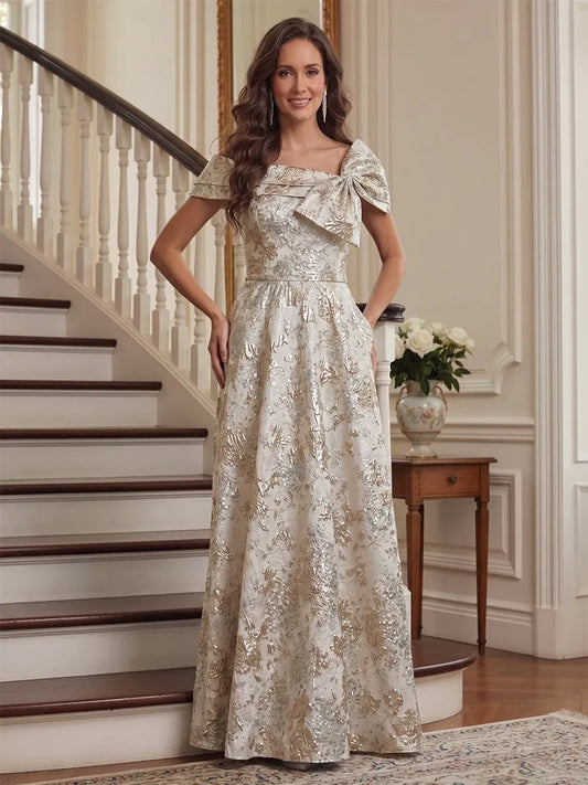 Loverlm champagne gold floral jacquard mother of the bride dress front view with off-shoulder neckline, statement bow and floor-length A-line skirt