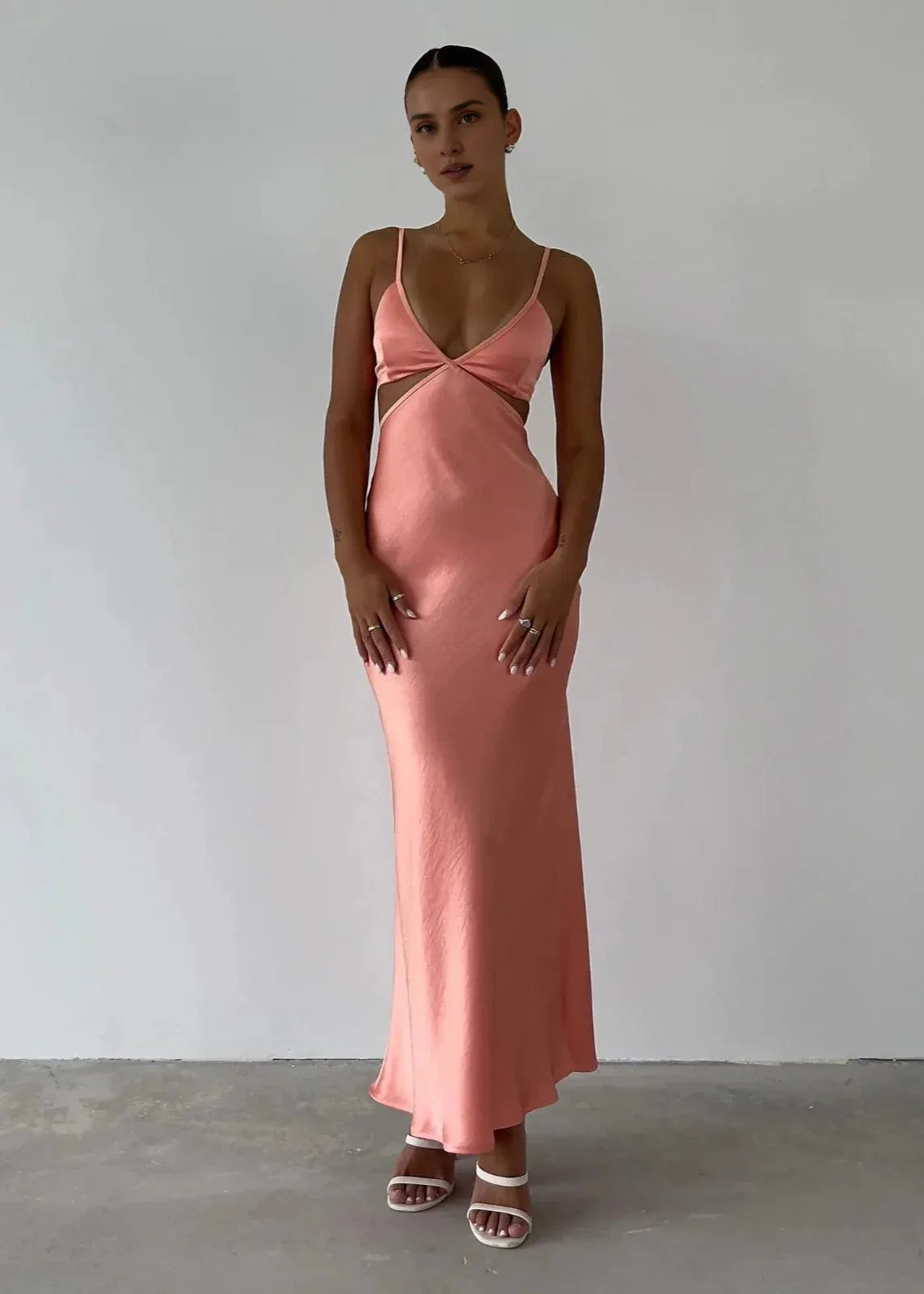 Loverlm coral pink satin wedding guest dress with plunging V-neck, spaghetti straps, twisted bust, side cutouts and fitted maxi skirt front view