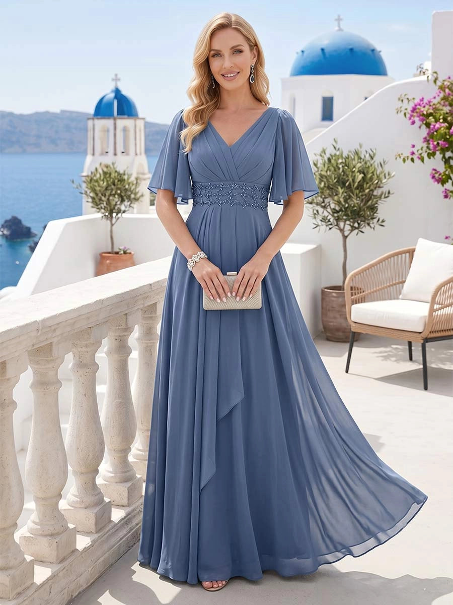 Front view of Loverlm dusty blue Mother of the Bride Dress with V-neckline, flutter sleeves, embellished waist and flowing floor-length A-line skirt.