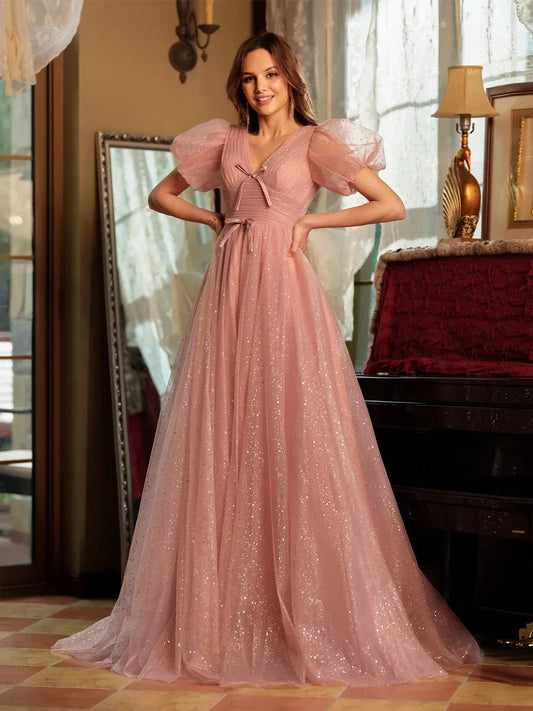 Front view of Loverlm dusty pink glitter tulle prom dress with V-neckline, puff sleeves, bow details and floor-length A-line skirt