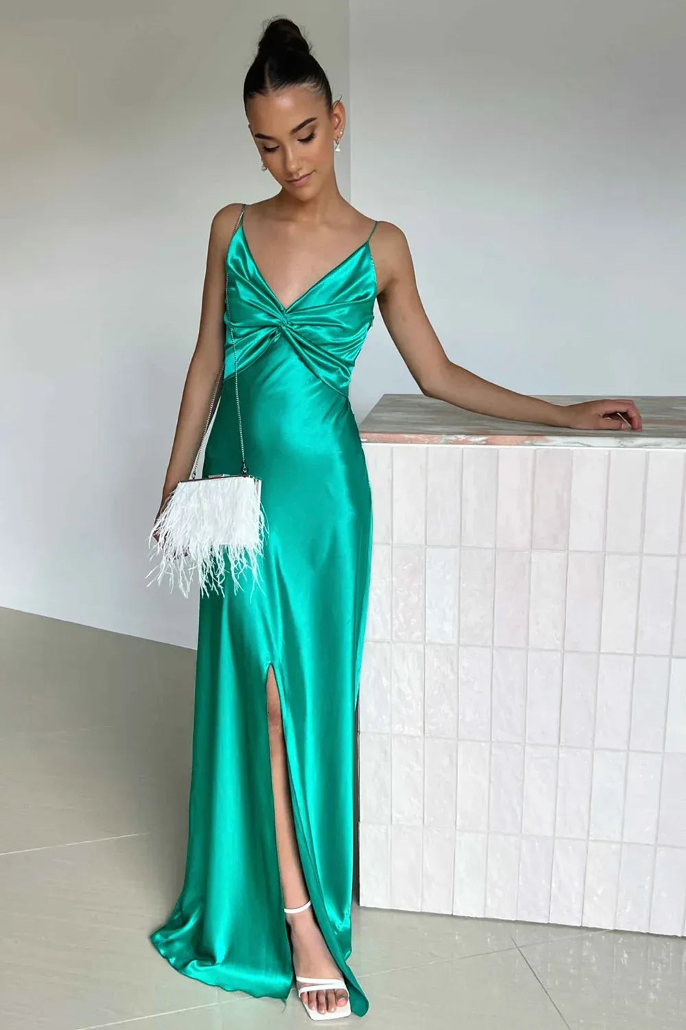 Loverlm emerald green satin evening dress with a twisted V-neck bodice, spaghetti straps and a floor-length sheath skirt with a front slit.