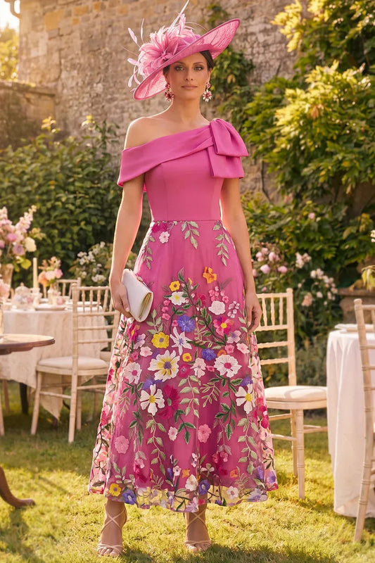 Front view of Loverlm fuchsia midi wedding guest dress with an asymmetric bow shoulder, fitted bodice and colourful floral embroidered tulle skirt.