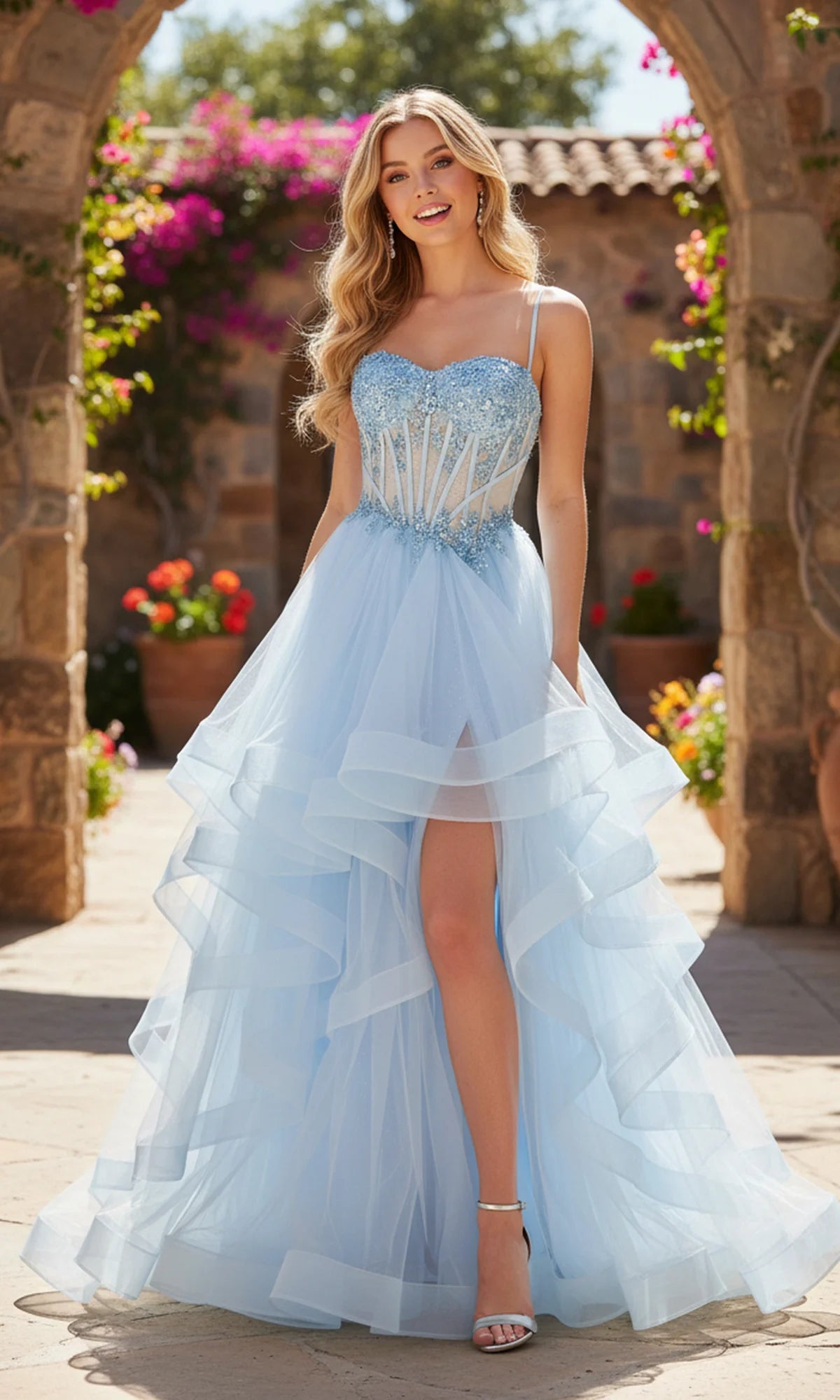 Light blue A-line tulle prom dress with beaded sweetheart corset bodice, spaghetti straps, cascading ruffled high-low skirt and front leg opening