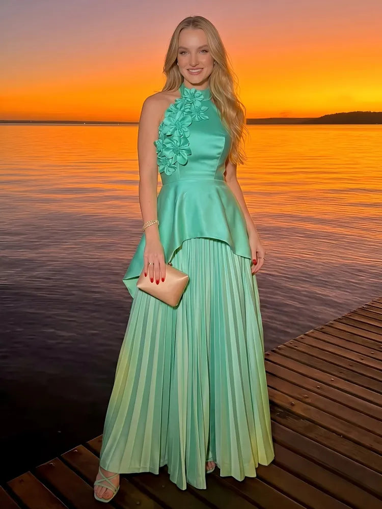 Mint green floral halter wedding guest maxi dress with 3D appliques, satin peplum overlay and flowing pleated skirt by Loverlm