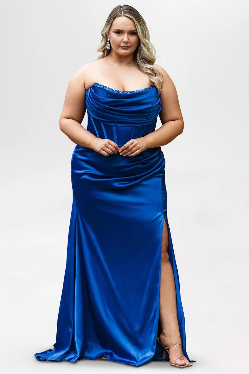 Plus size cobalt blue satin prom dress with strapless rhinestone-trimmed cowl neckline, sheer corset bodice, ruched waist, thigh-high slit, and floor-length skirt