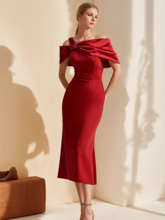 Front view of Loverlm ruby red asymmetric wedding guest dress with draped shoulder detail, jeweled accent, fitted sheath silhouette and midi hem