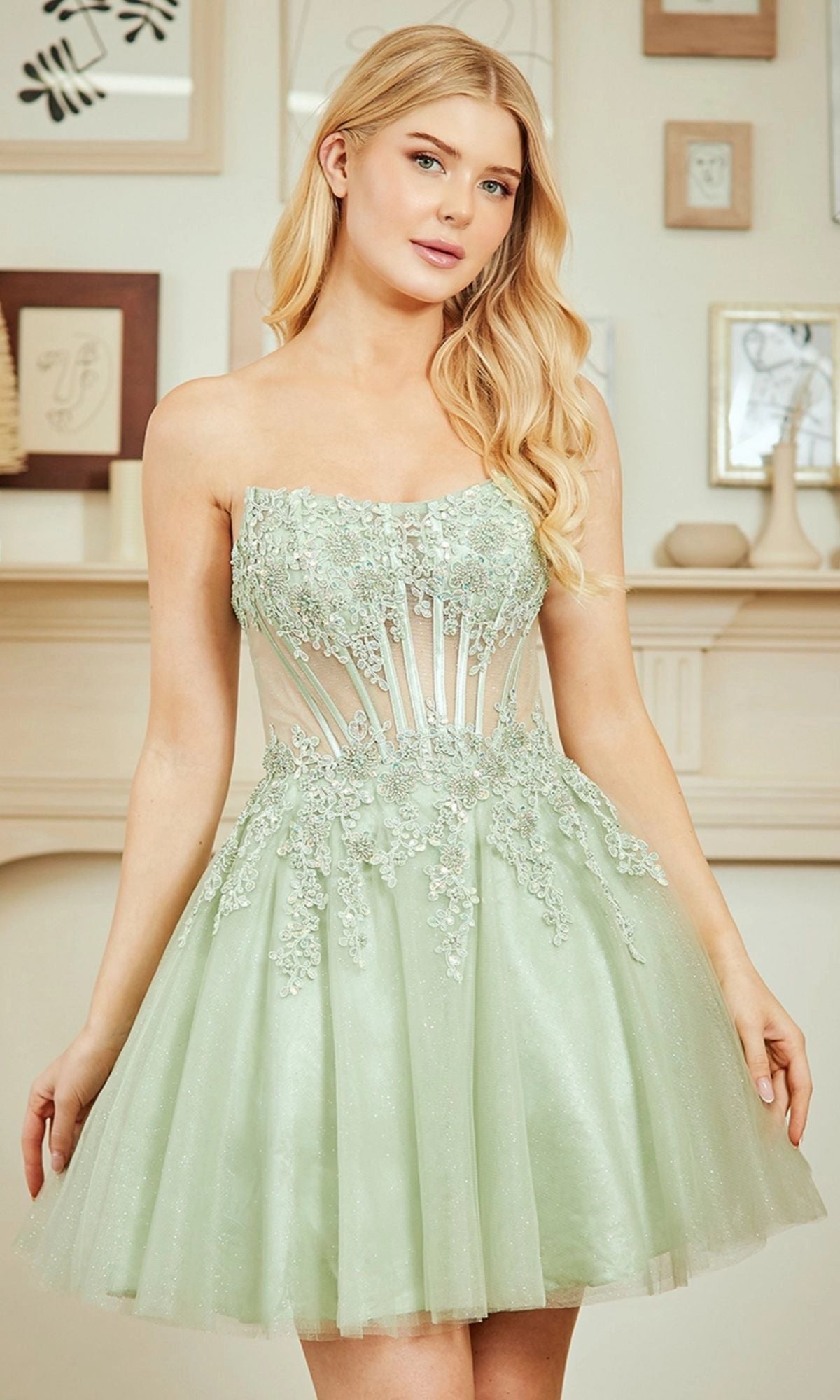 Sage green strapless A-line homecoming dress with sweetheart neckline, sheer corset bodice, floral lace appliques and glitter tulle mini skirt by Loverlm